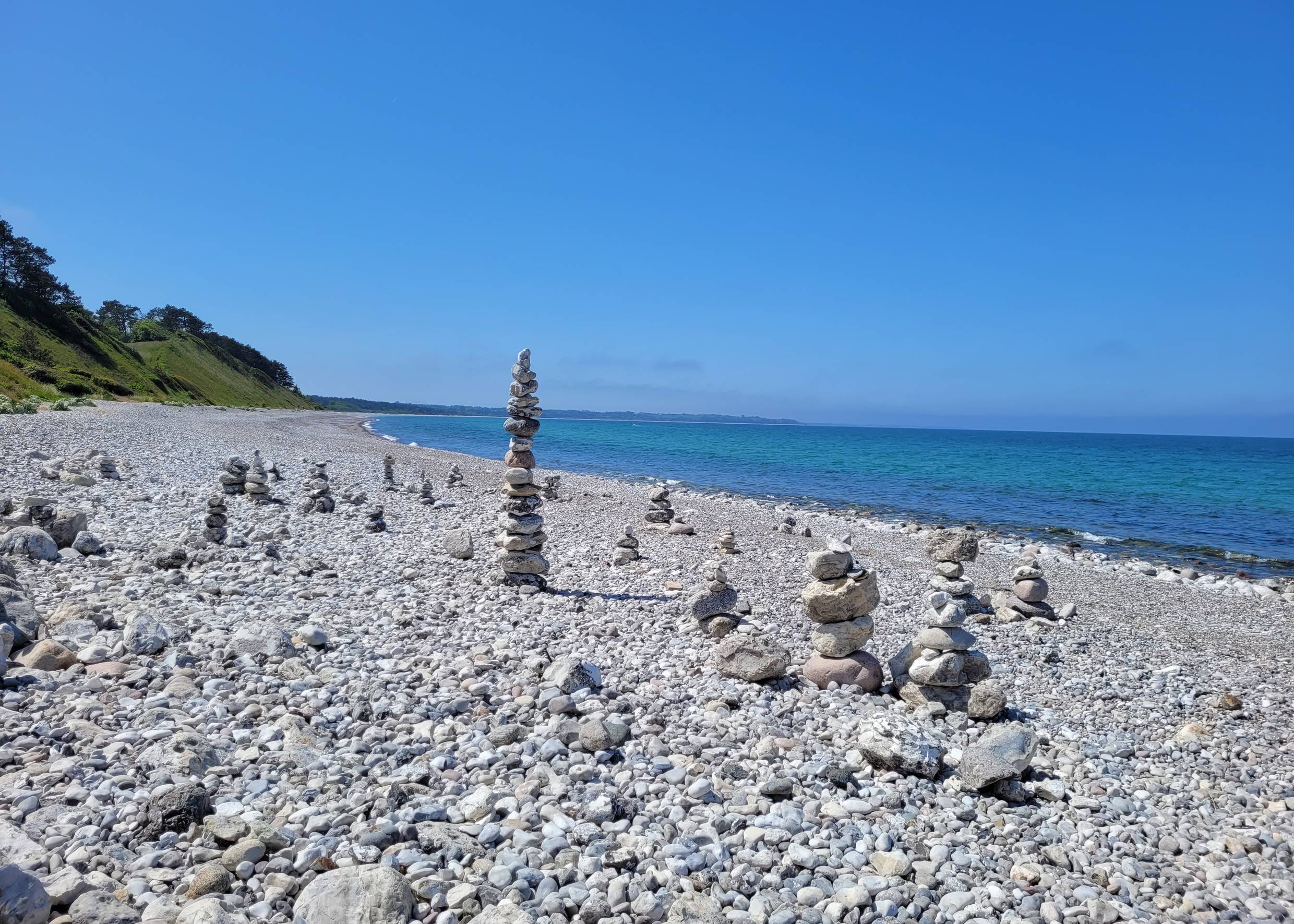 Steiniger Strand mit kleinen türmen aus runden Kieseln