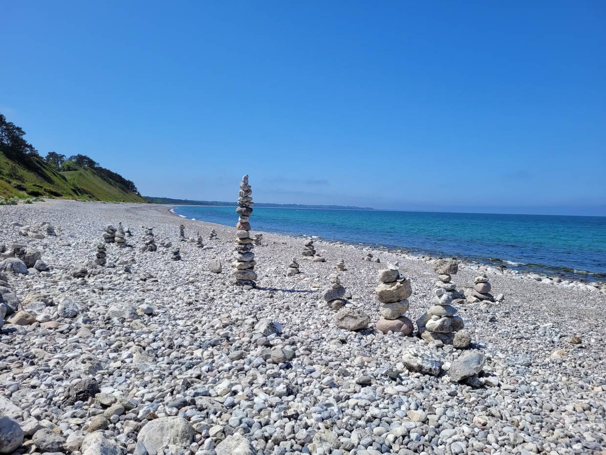 Steiniger Strand mit kleinen türmen aus runden Kieseln