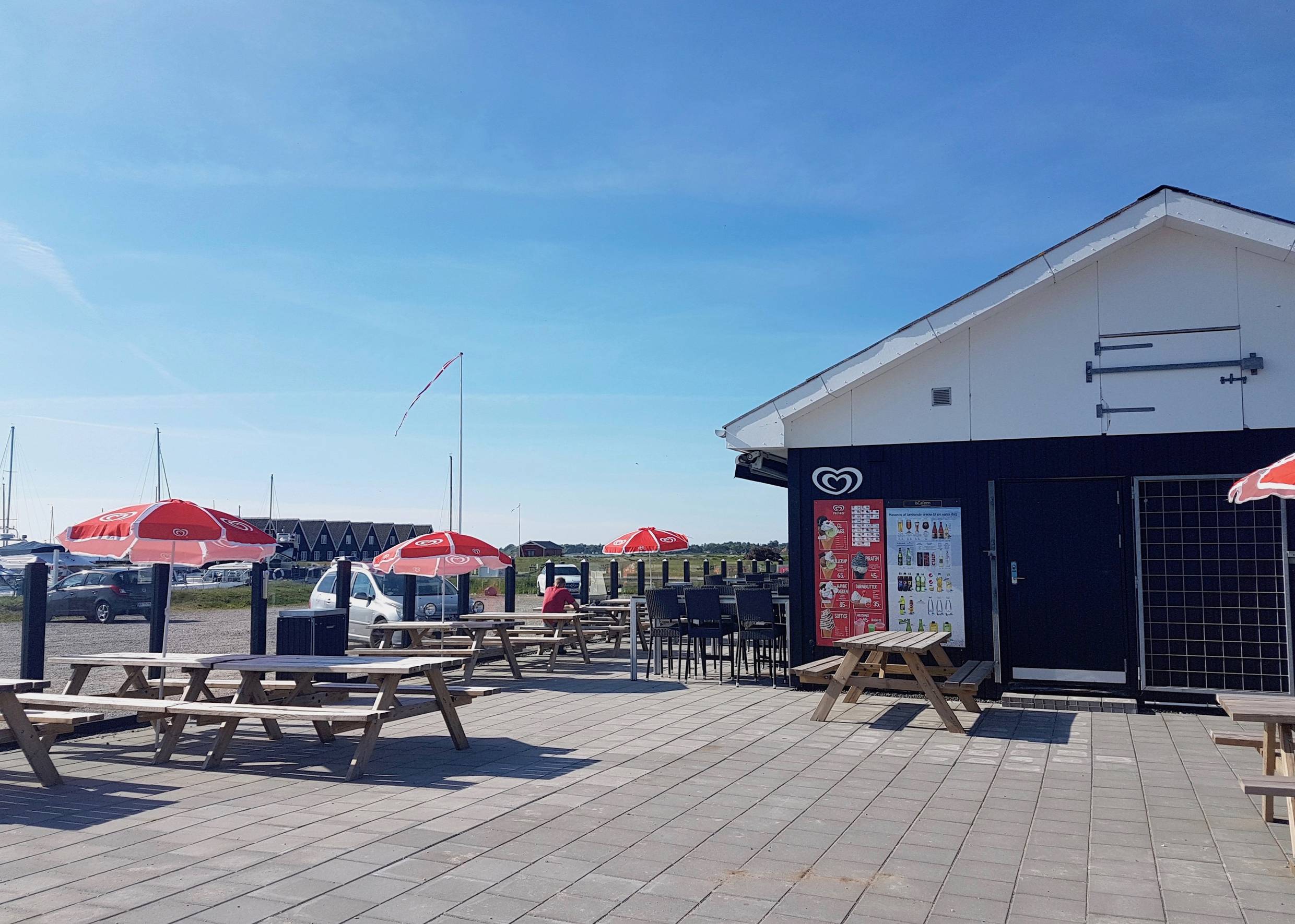 Schwarzes Holzhaus mit Eiscafé und Gastterrasse