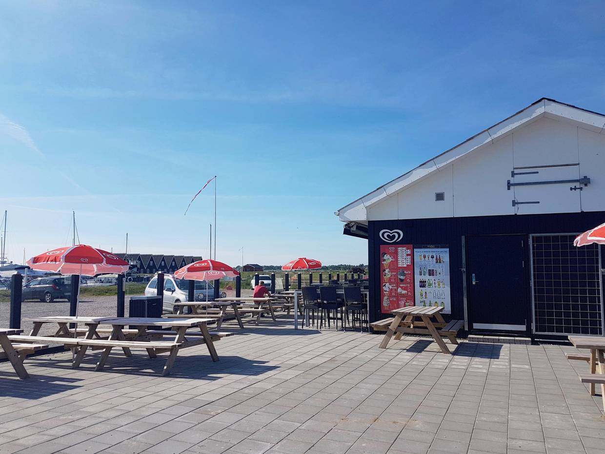 Schwarzes Holzhaus mit Eiscafé und Gastterrasse