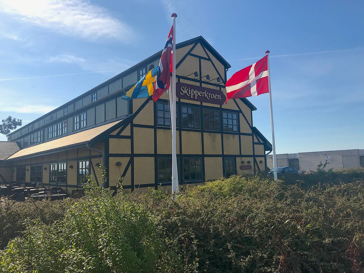 Gelb-schwarzes großes Hotel im Fachwerkstil, dafür Fahnen im Wind