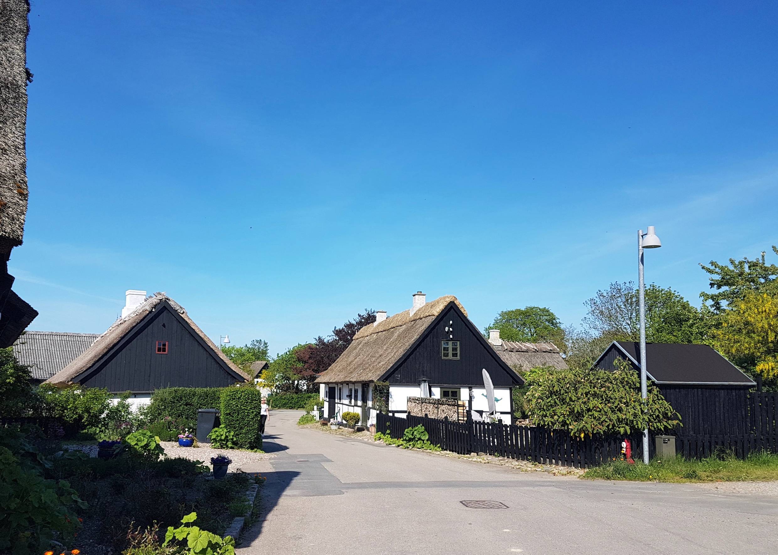 Straße mit kleinen, weißen Reetdachhäusern