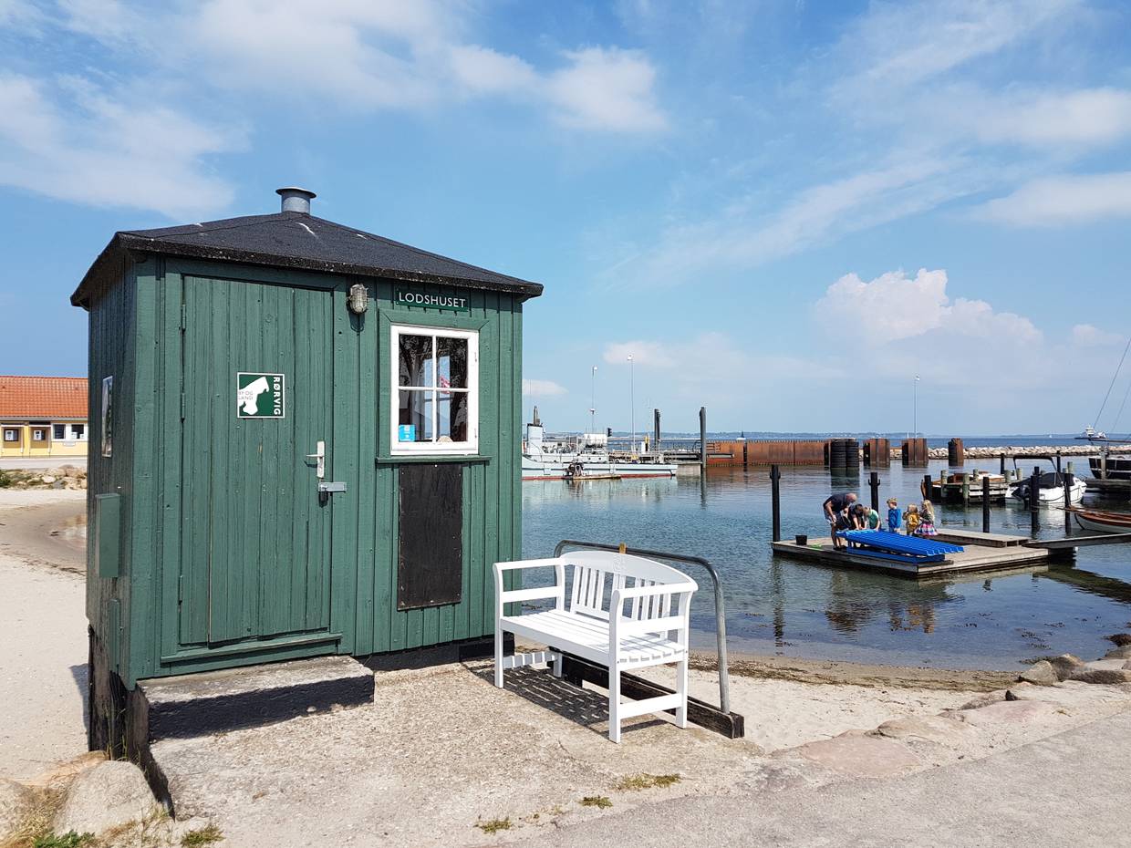 Grünes Lotsenhaus am Hafen, dahinter Restaurantterrassen