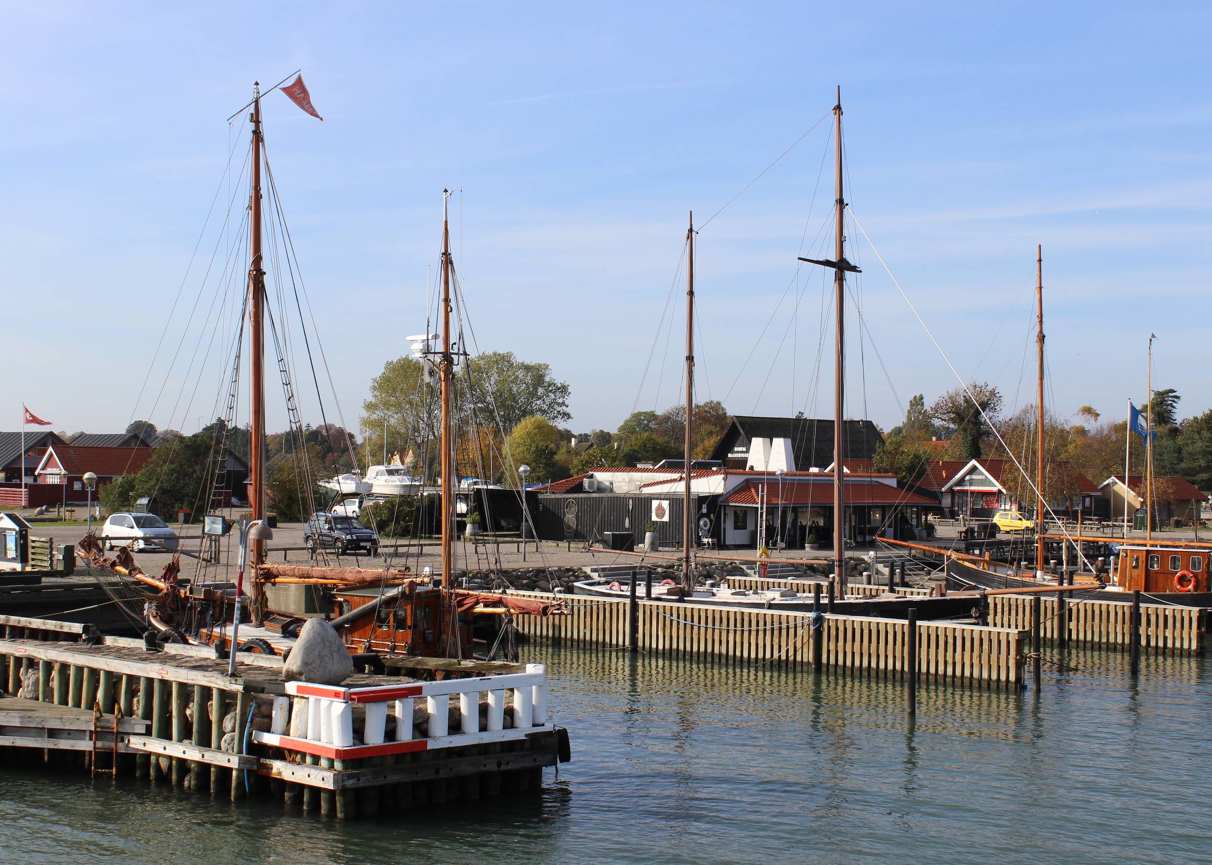 Blick auf Holzboote und eine Fischräucherei im Hafen