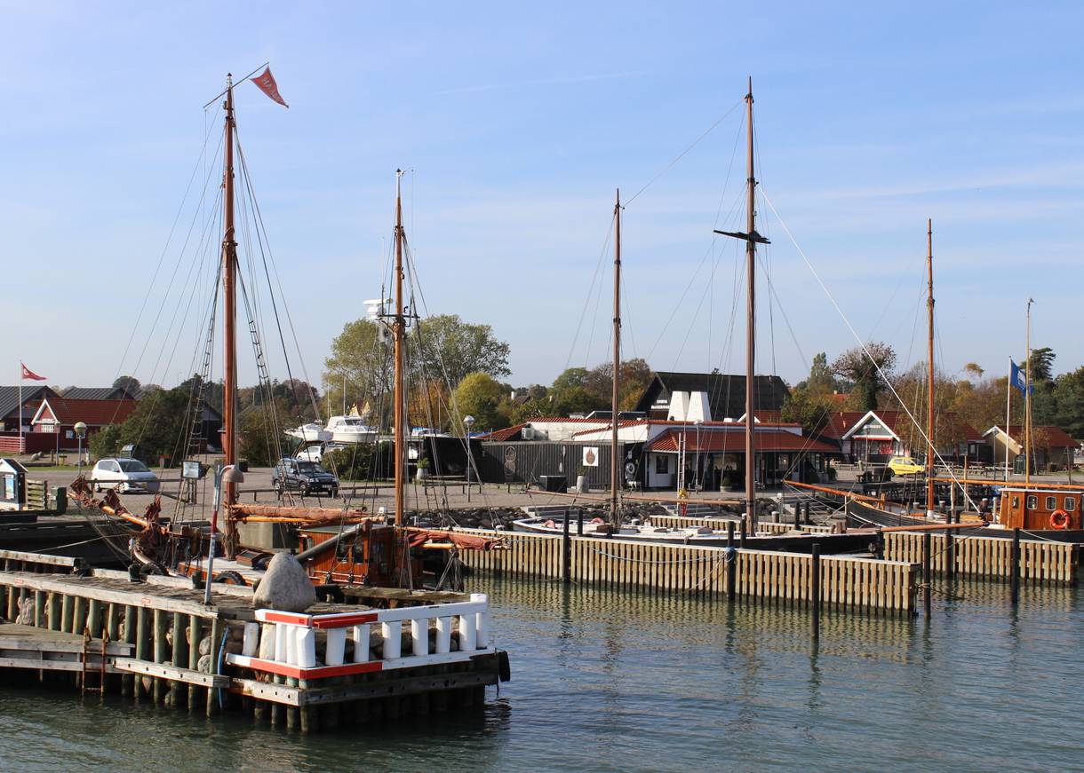 Blick auf Holzboote und eine Fischräucherei im Hafen