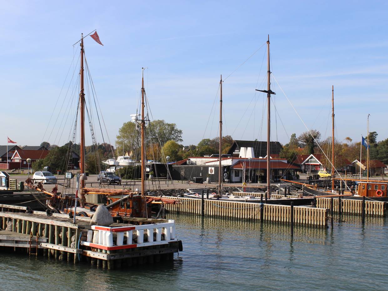 Blick auf Holzboote und eine Fischräucherei im Hafen