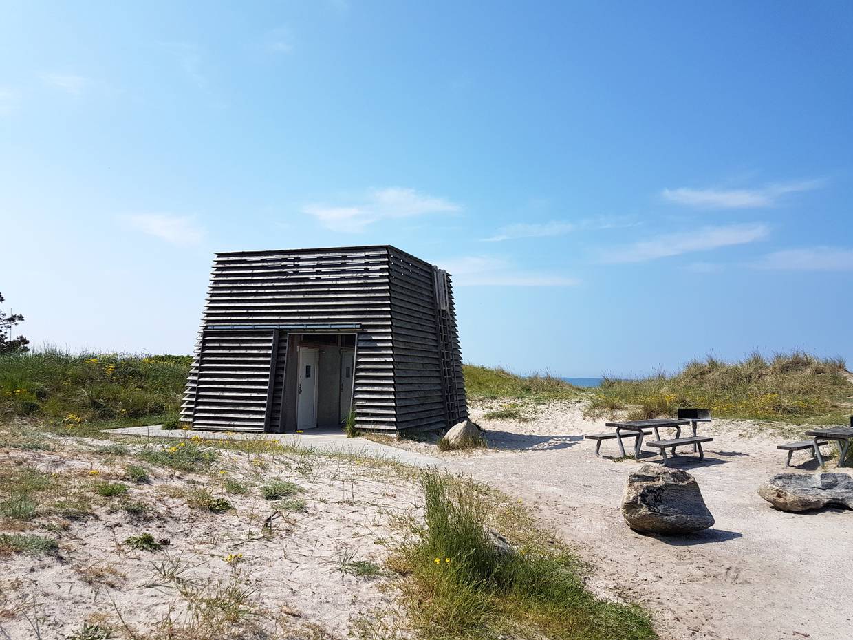 Viereckiger Holzturm, davor Picknickbänke am Rørvig Strand