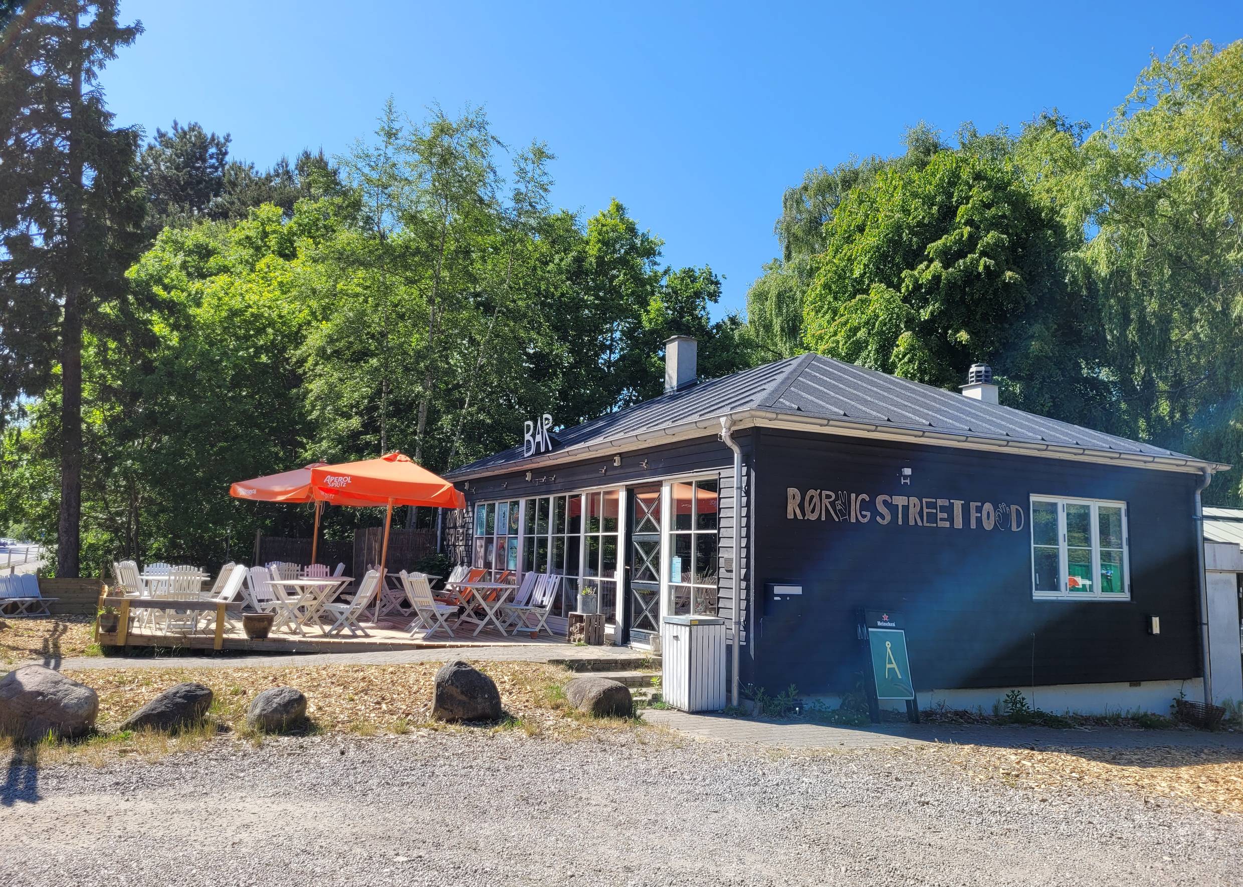 Bistro mit Außensitzplätzen vor einem Waldstück