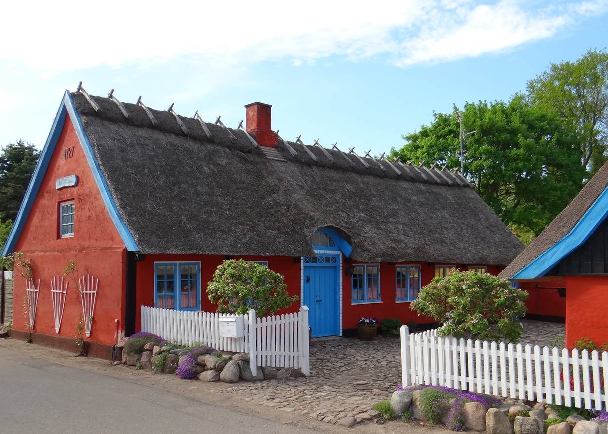 Rotes Reetdachhaus mit blauen Fenstern
