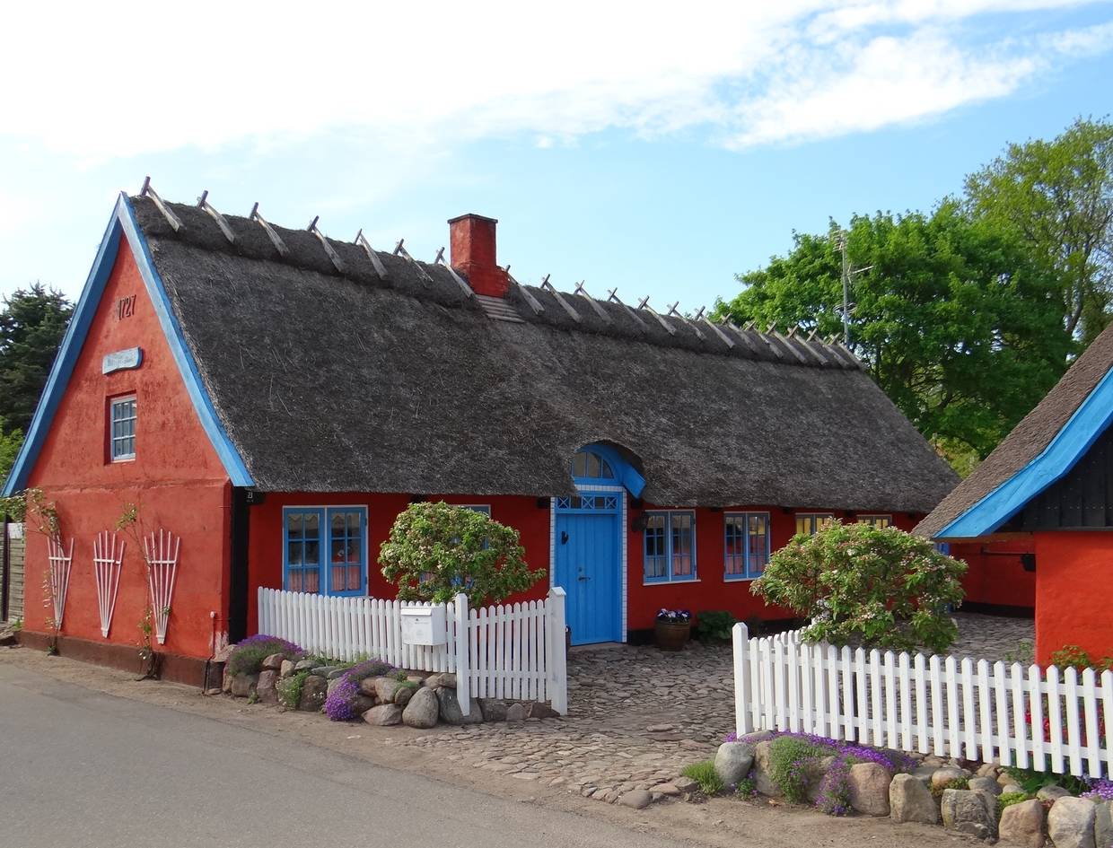 Rotes Reetdachhaus mit blauen Fenstern