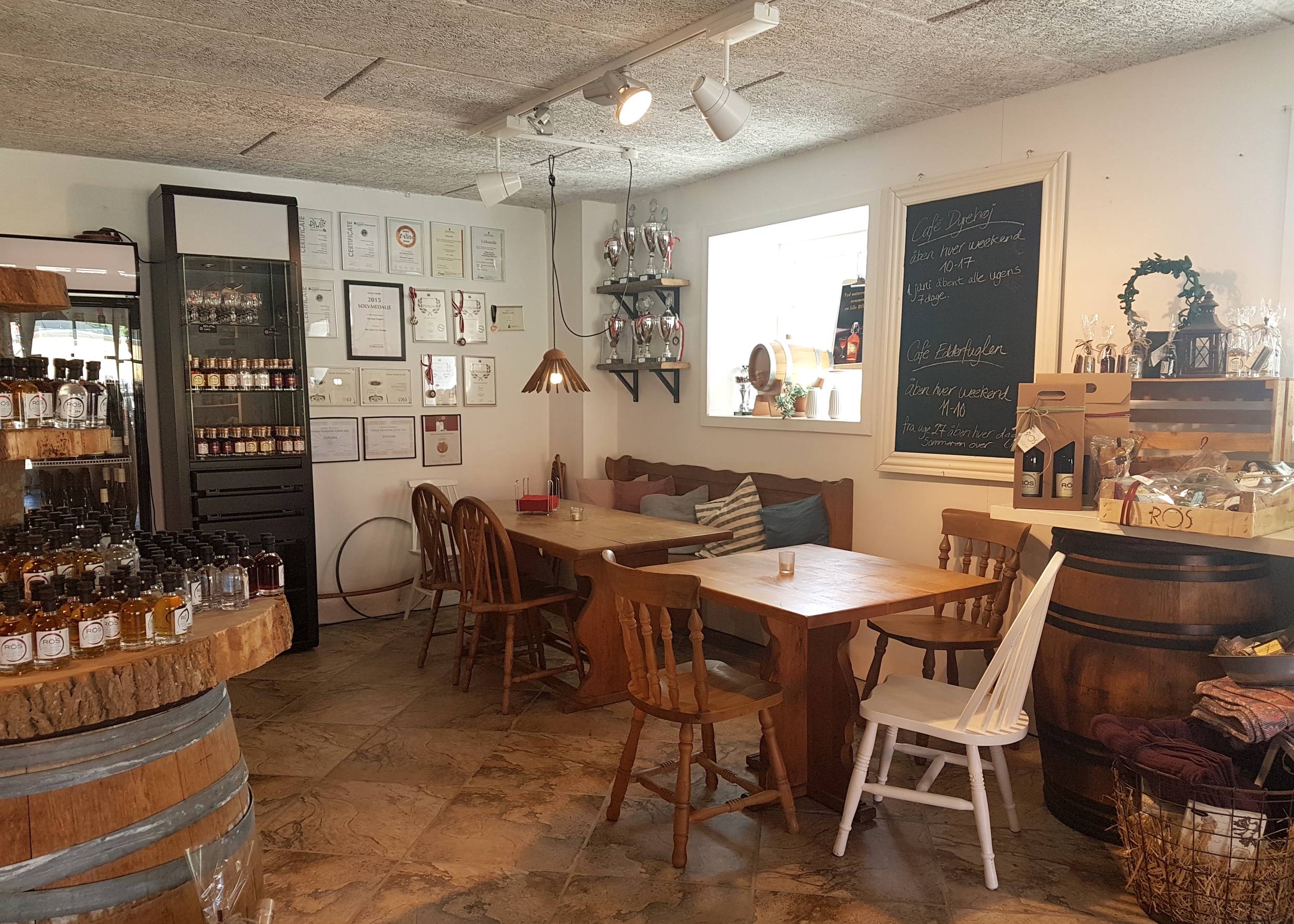 Blick in eine Sitzecke im Café mit Holzmöbeln und Urkunden an der Wand
