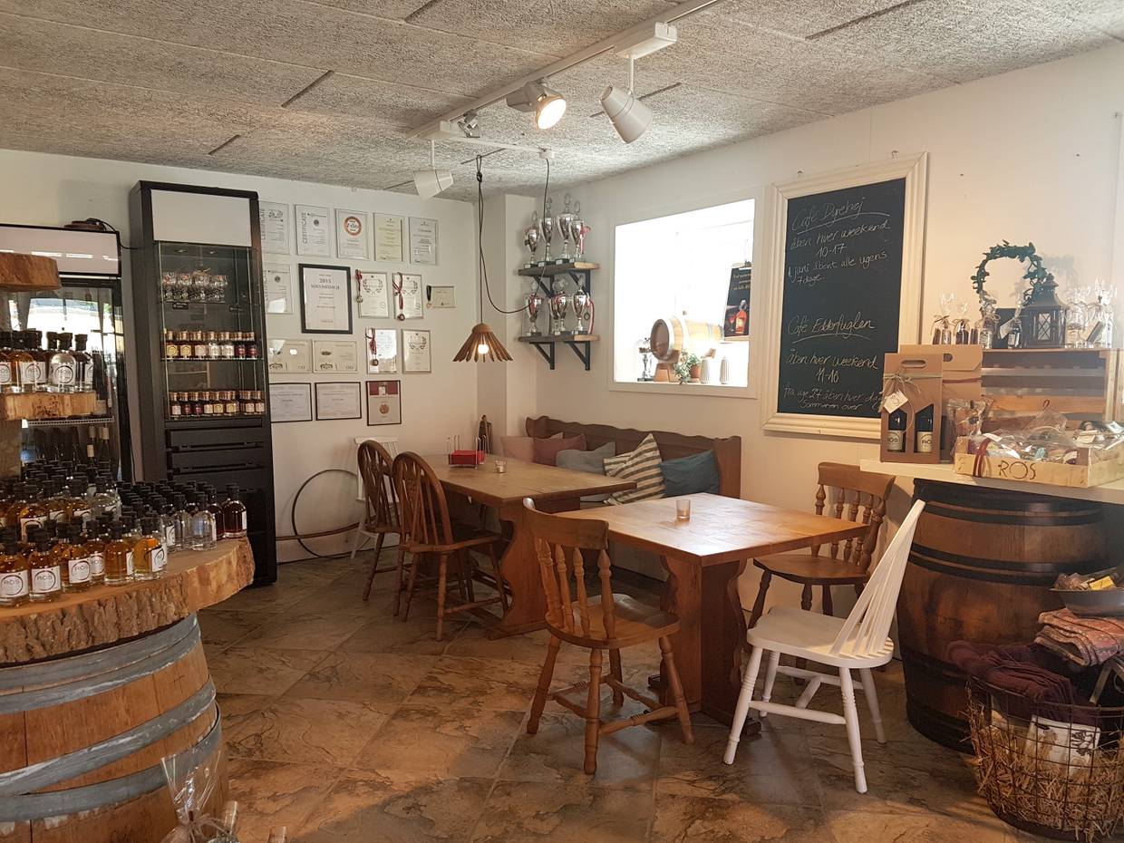 Blick in eine Sitzecke im Café mit Holzmöbeln und Urkunden an der Wand