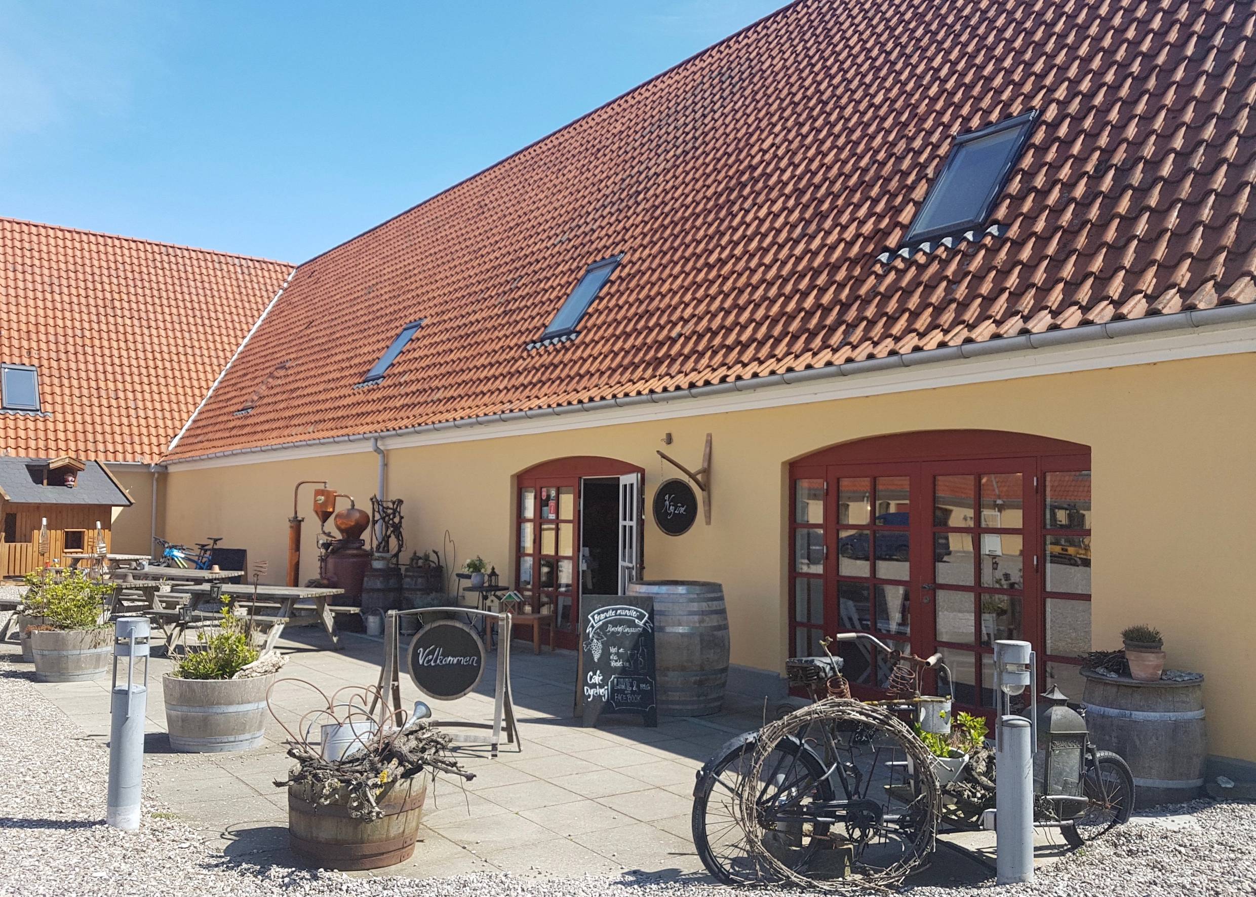 Eingang zum Hofladen mit allerlei Deko und Bänken