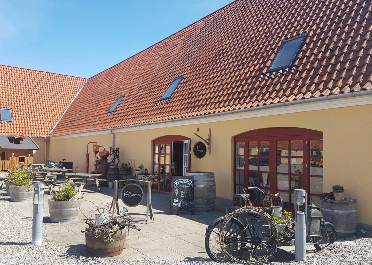 Eingang zum Hofladen mit allerlei Deko und Bänken