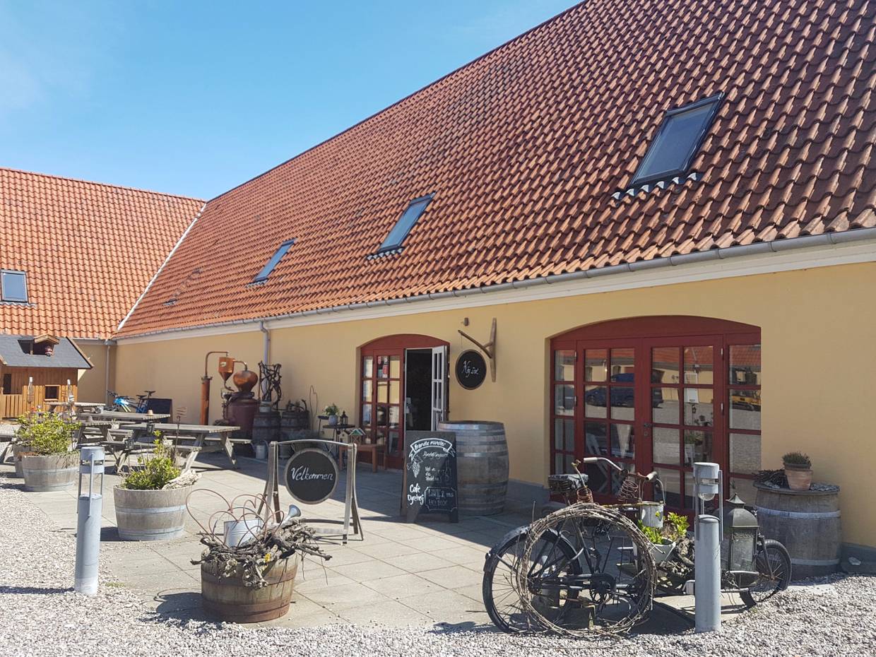Eingang zum Hofladen mit allerlei Deko und Bänken