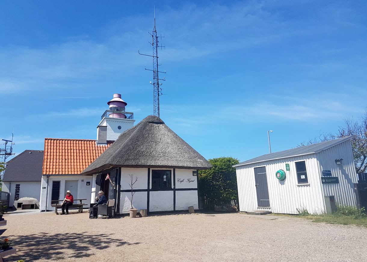 Kleiner, weißer Leuchtturm mit Nebengebäude