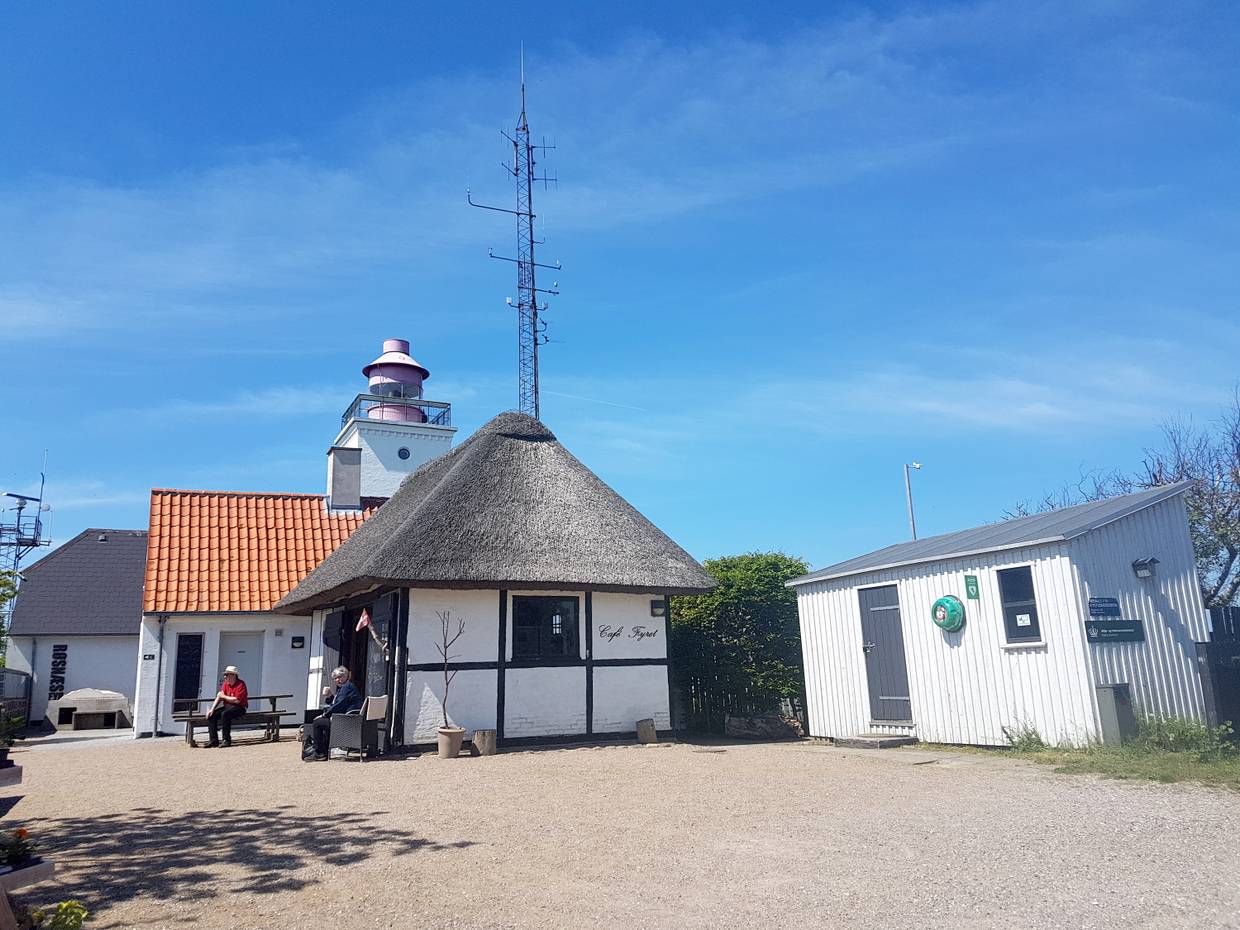 Kleiner, weißer Leuchtturm mit Nebengebäude