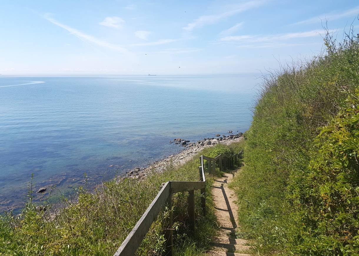 Treppe zum steinigen Strand