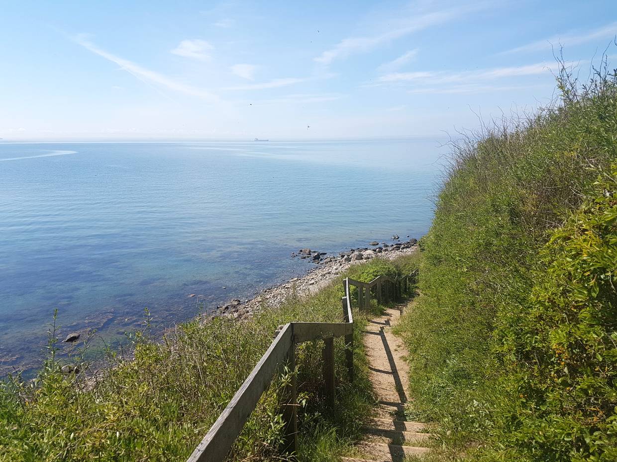 Treppe zum steinigen Strand