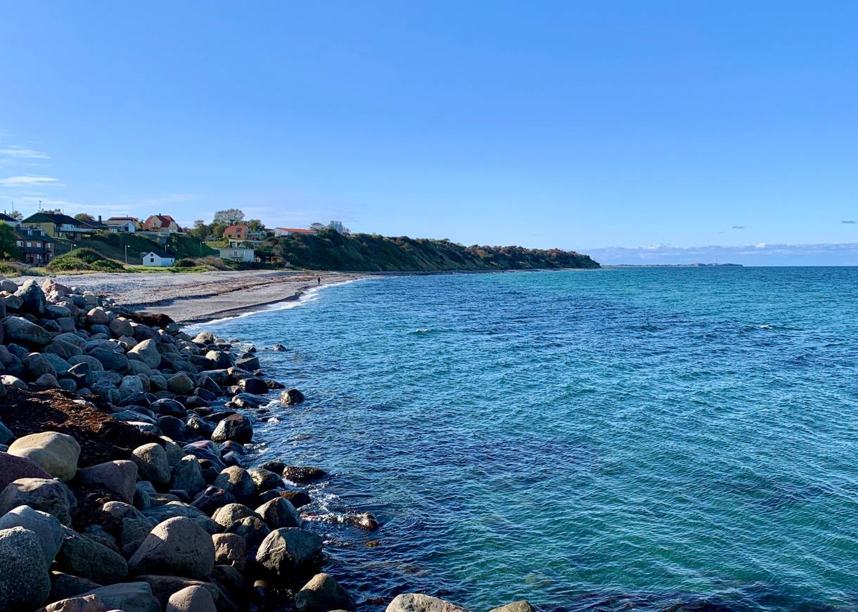 Blick auf eine Bucht unterhalb der Häuser am Hang