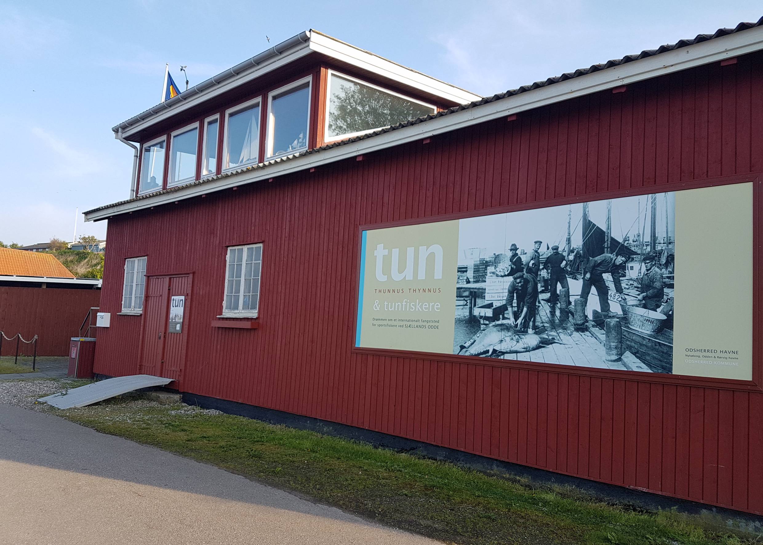 Holzhaus mit Hinweisschild zu einer Ausstellung