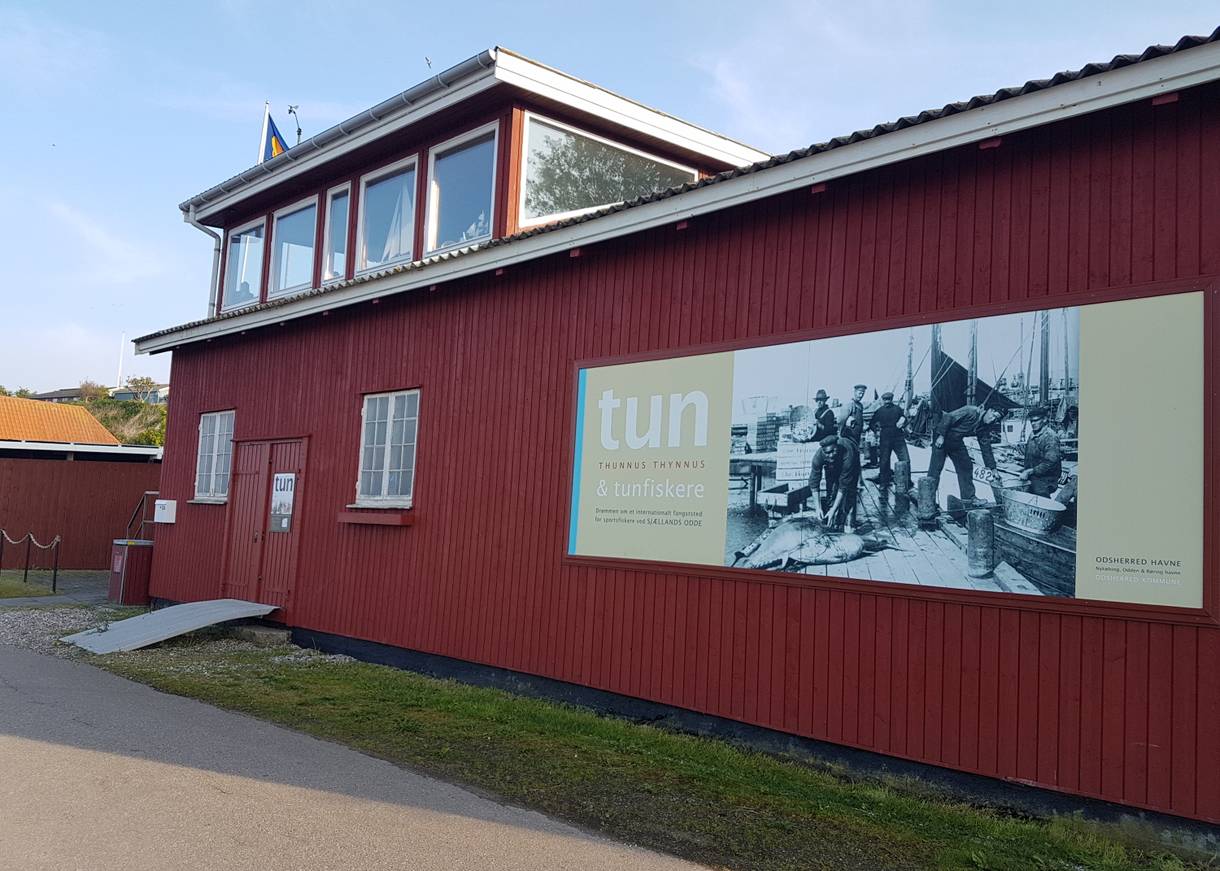 Holzhaus mit Hinweisschild zu einer Ausstellung