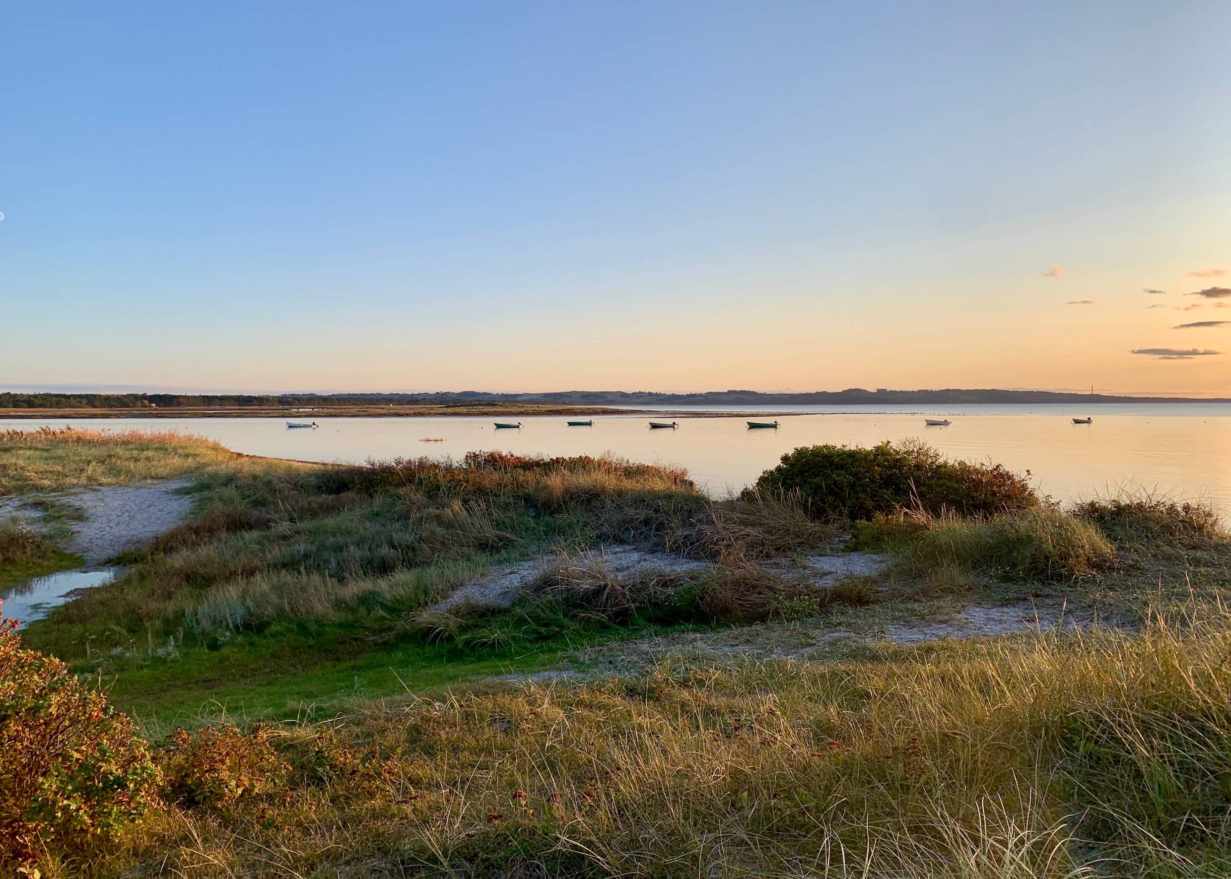 Abendsonne über einer Lagune mit kleinen Booten auf dem Wasser
