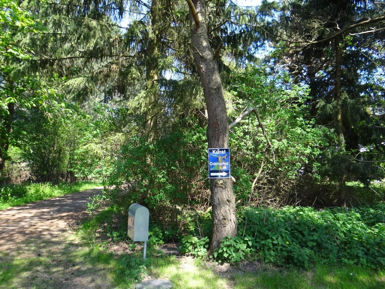 Hinweisschld zur Kunstausstellung an einem Baum