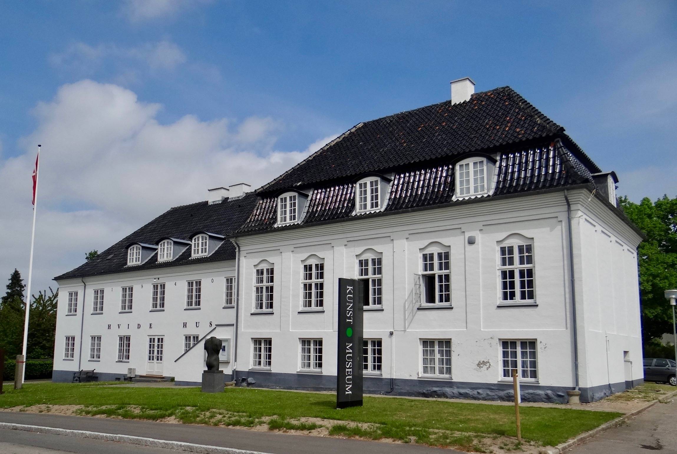 Weißes altes Stadthaus mit schwarzem Dach