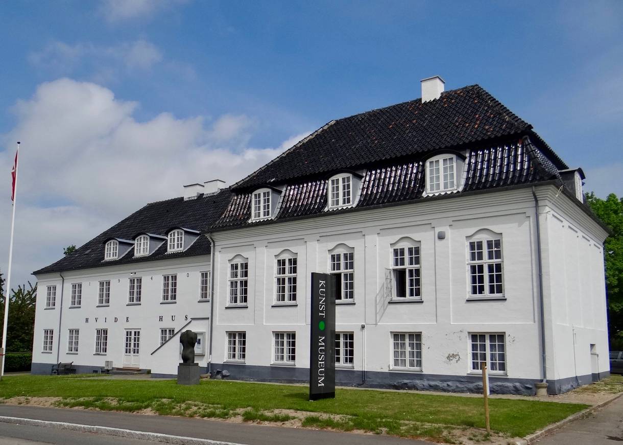 Weißes altes Stadthaus mit schwarzem Dach