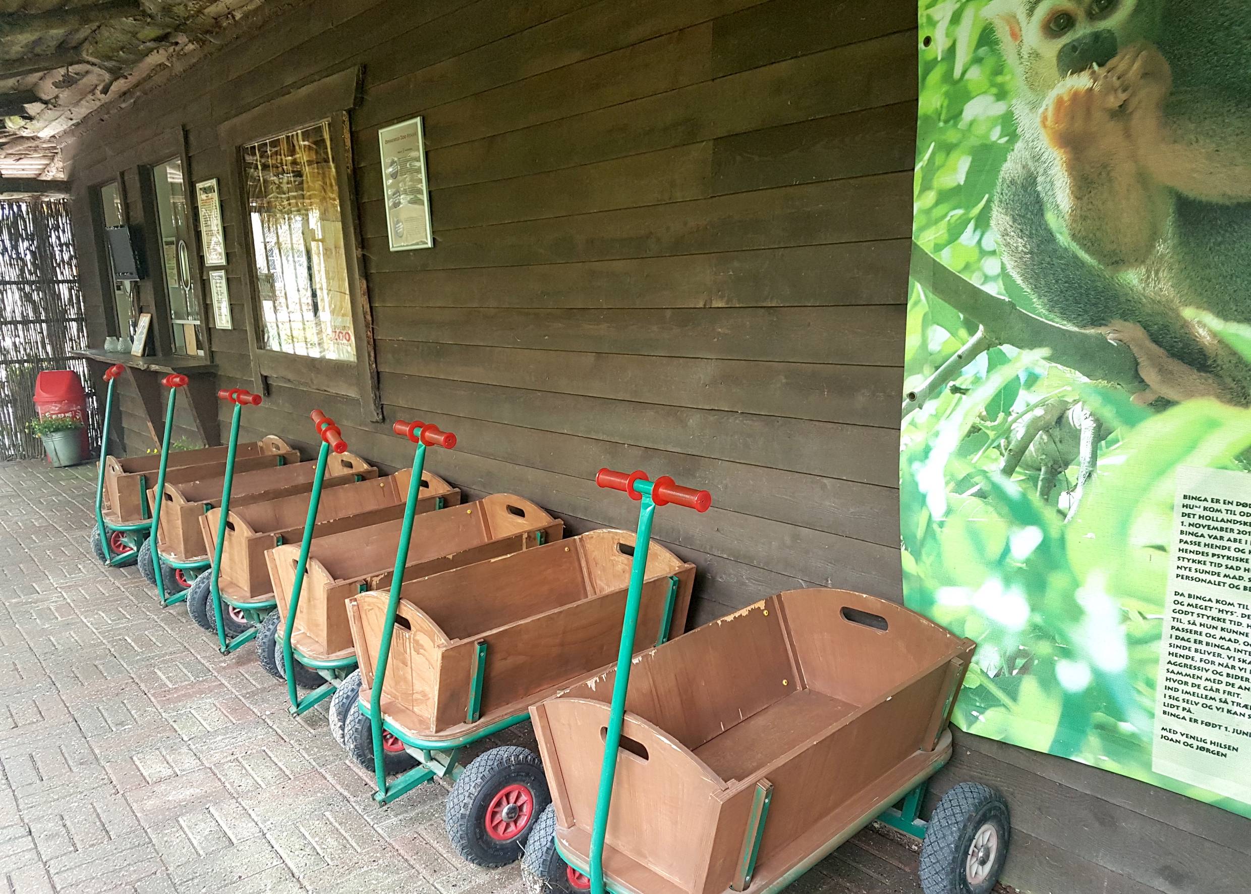Bollerwagen vor einer schwarzen Holzwand