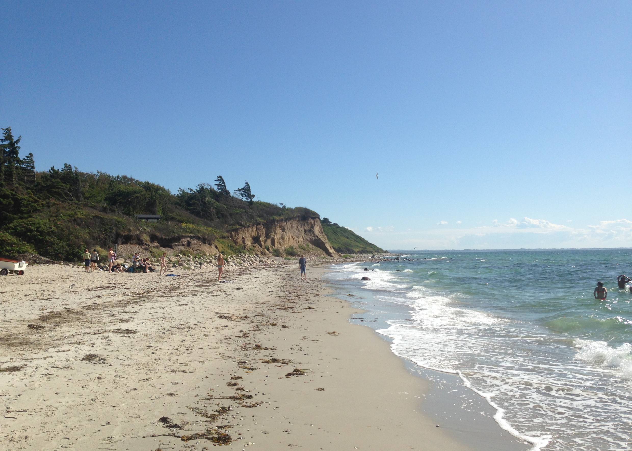 Sandstrand mit Badegästen vor einer Steilküste